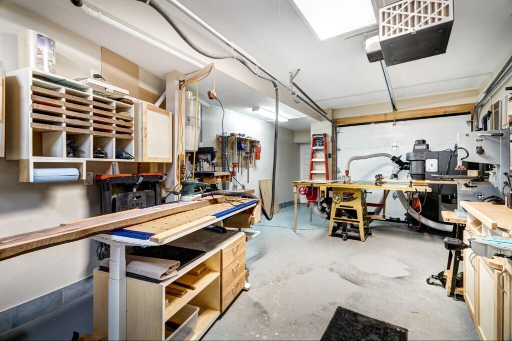 a garage that's acting as a workshop and has ceiling lights.