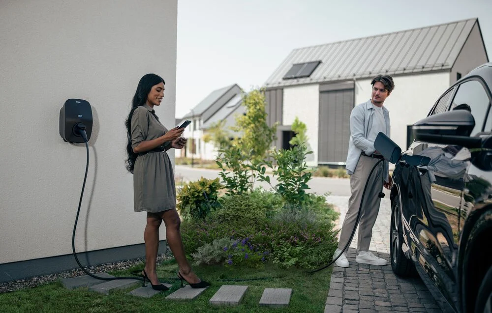 An EVBox Livo charging station being used by a couple.