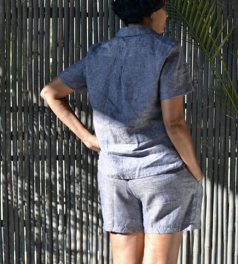Back view of a woman wearing a button-up pajama shirt and pajama shorts