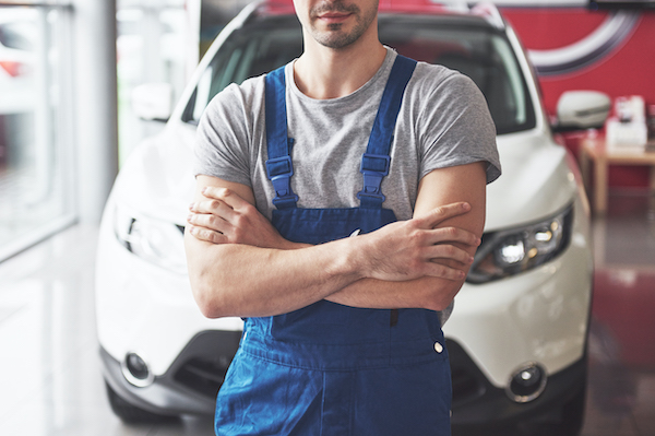 Hand of car mechanic with wrench. Auto repair shop.