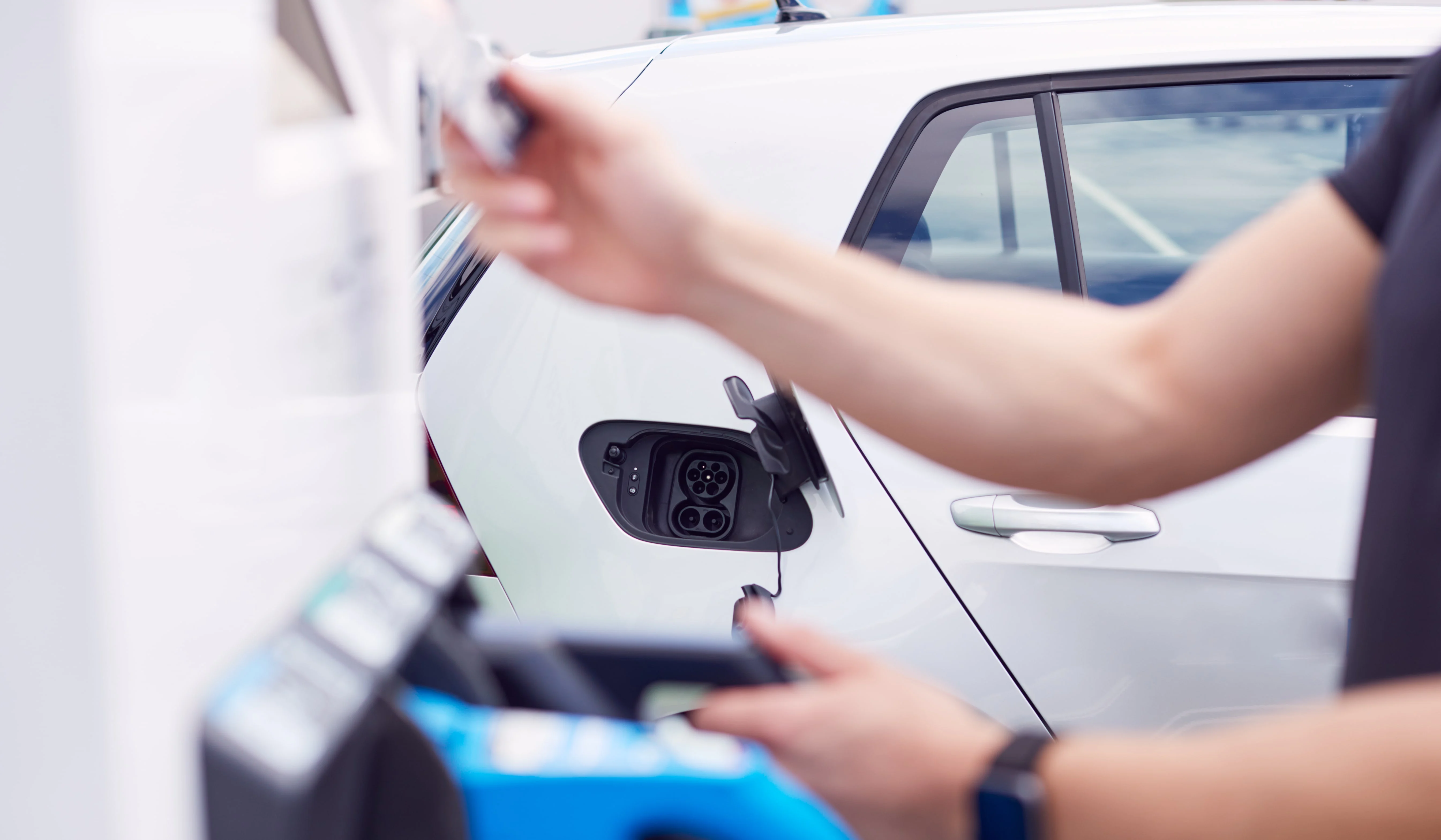A man grabbing a fast charging plug from the station.