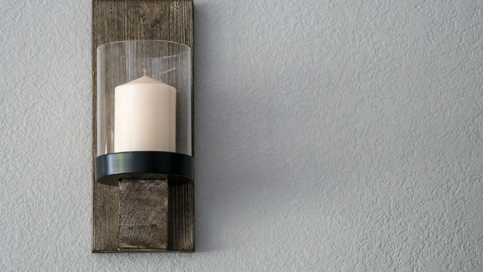A candle on a wooden sconce