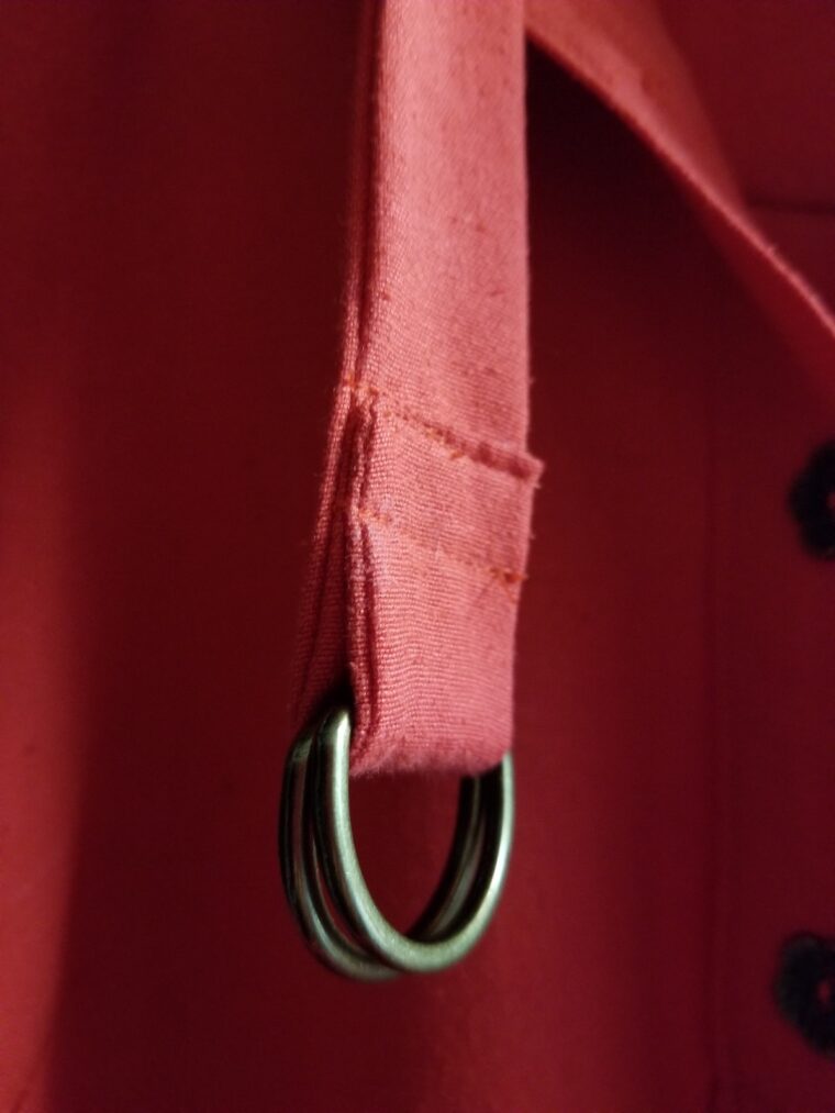 Close up of belt made with fashion fabric and D-rings.