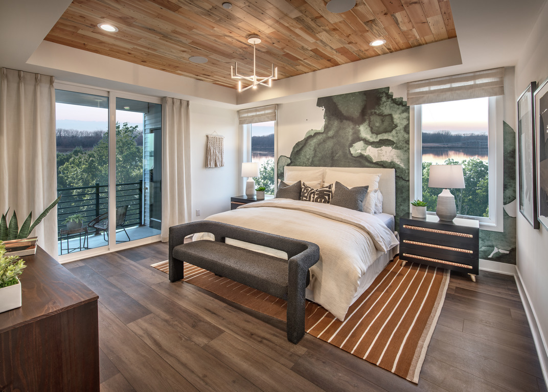 Primary bedroom with an accent wall featuring watercolor wallpaper
