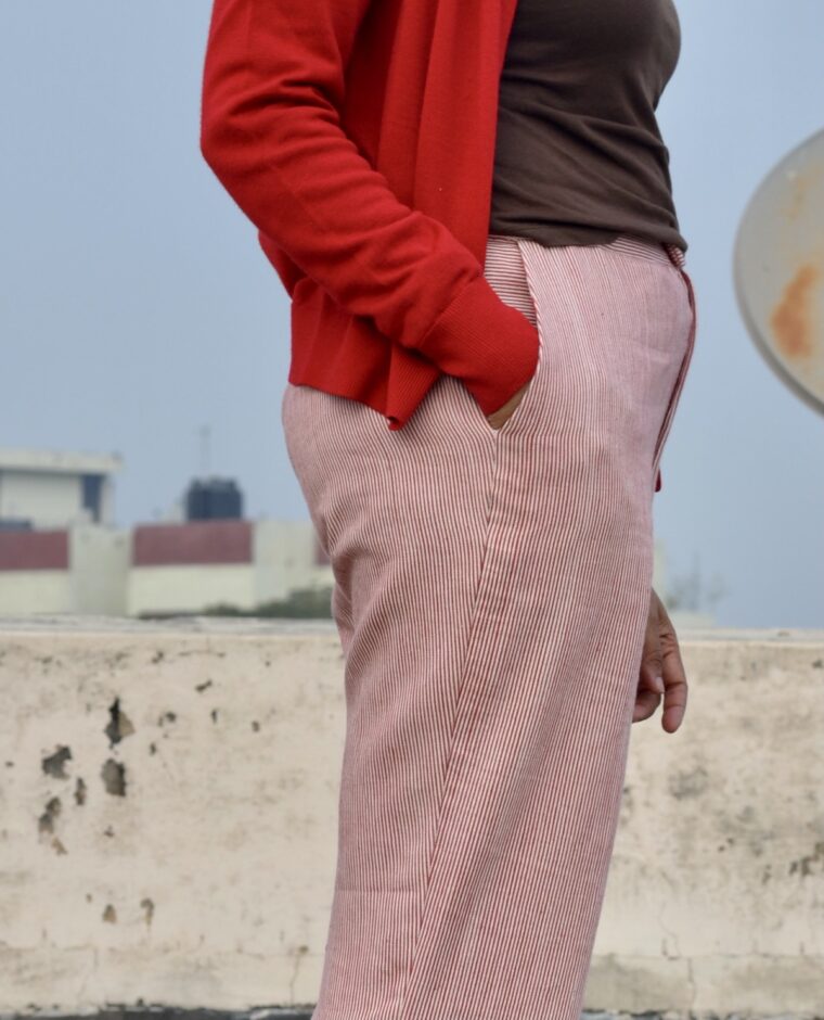 A close-up of a side trouser pocket with a hand inserted.