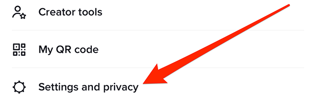 Screenshot of TikTok's profile menu with a red arrow pointing at "Settings and privacy"