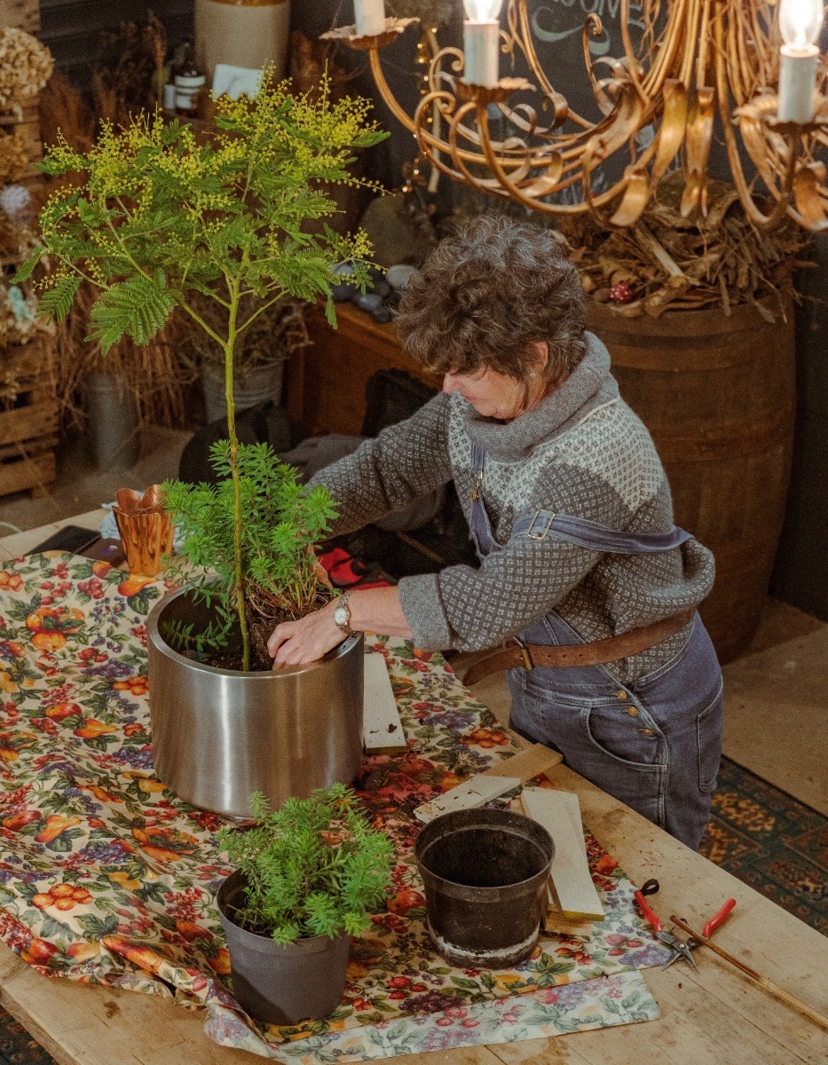 Woman planting in a Satin Marine Stainless Steel Newlyn plant pot.