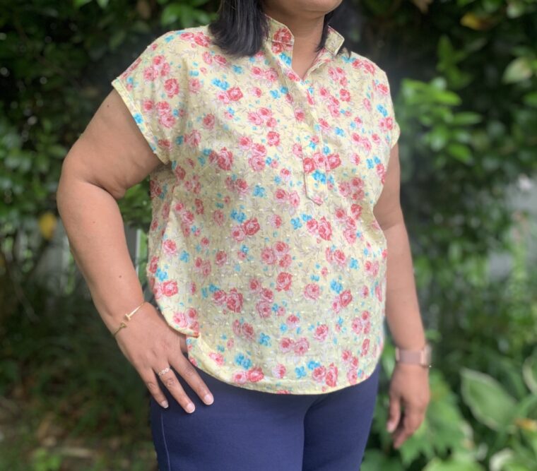 Side picture of a woman from the shoulders down wearing a pullover blouse.
