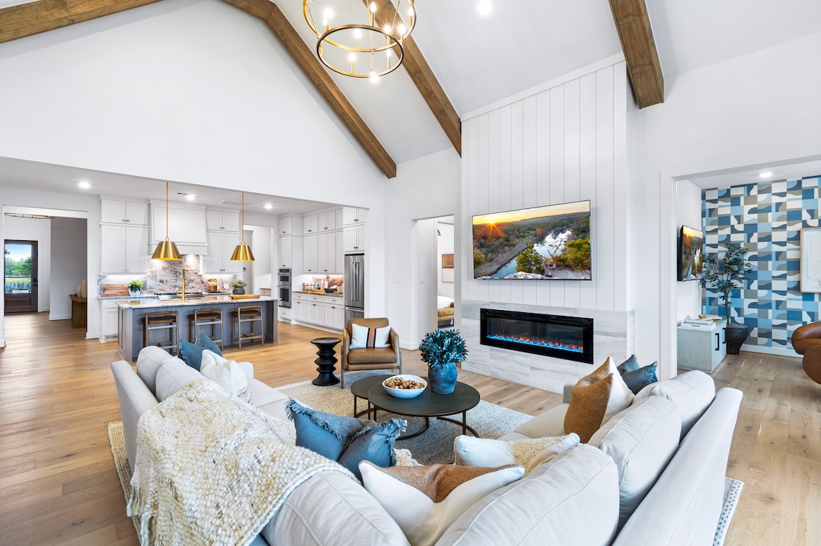 luxury modern farmhouse interior with open concept layout, contemporary fireplace, and wooden ceiling accents