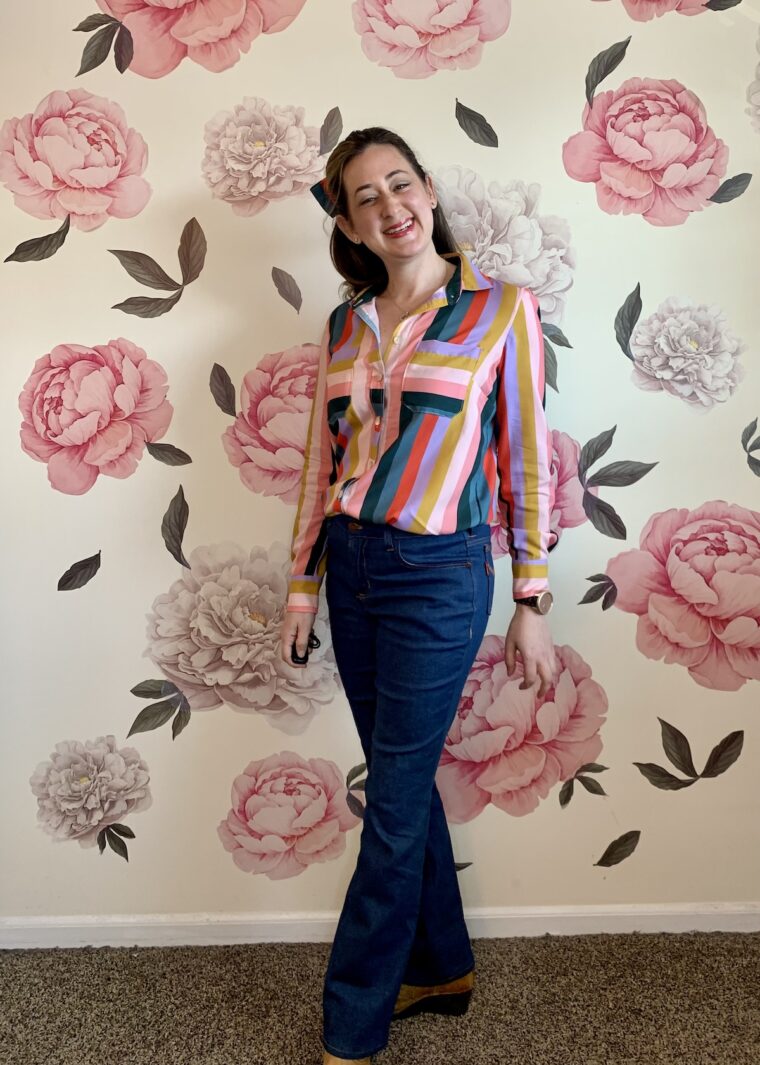 Front view of a woman wearing a button-down shirt and jeans.