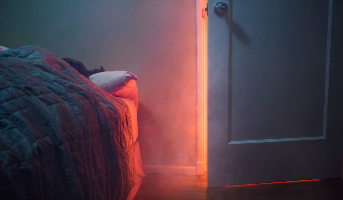 Internal fire doors - person in bed in bedroom with fire behind door on landing