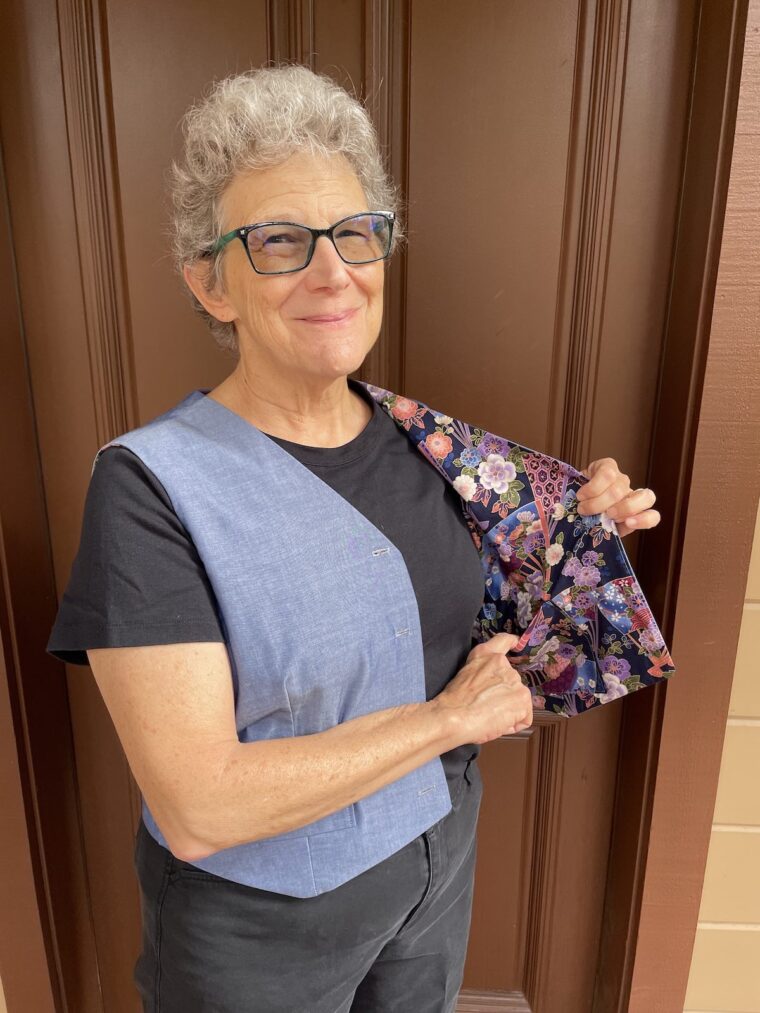 Woman showing off the beautiful lining of a vest.