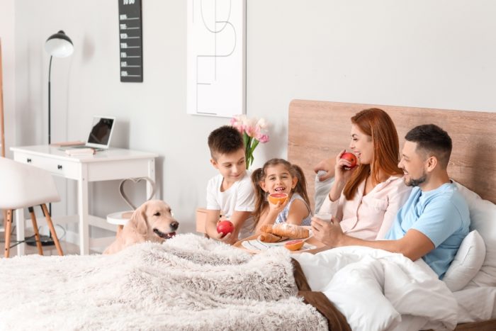 Source: https://stock.adobe.com/uk/images/happy-family-having-breakfast-in-bedroom-at-home/328174745