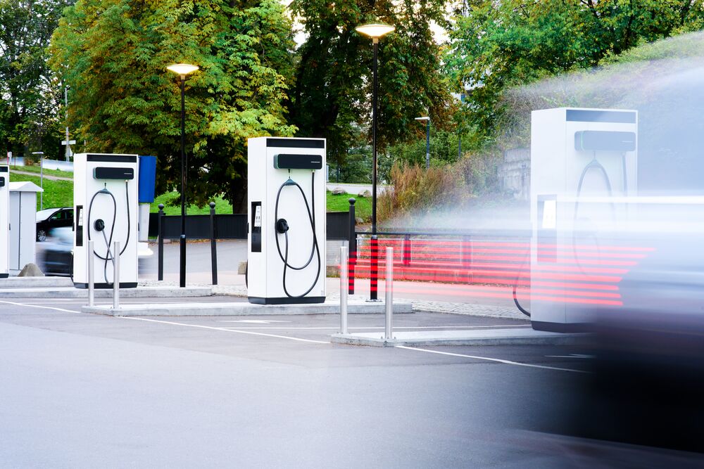 Zooming lights pass a row of EVBox Troniq Modular charging stations