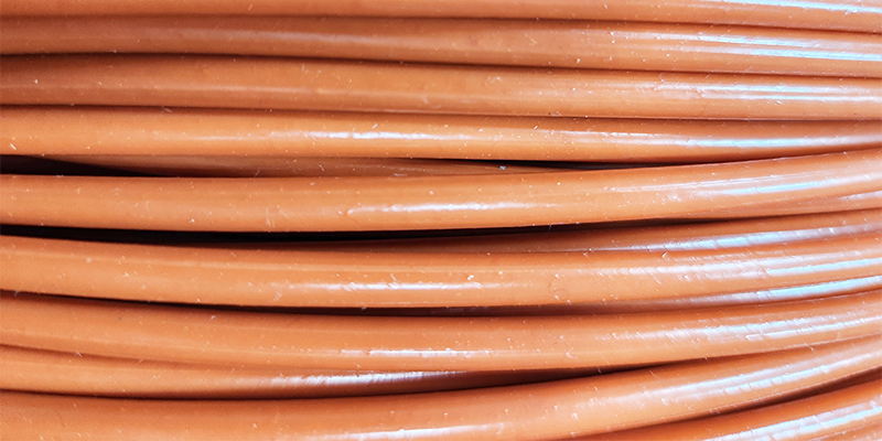 Galvanized wire rope with a safety orange vinyl coating.