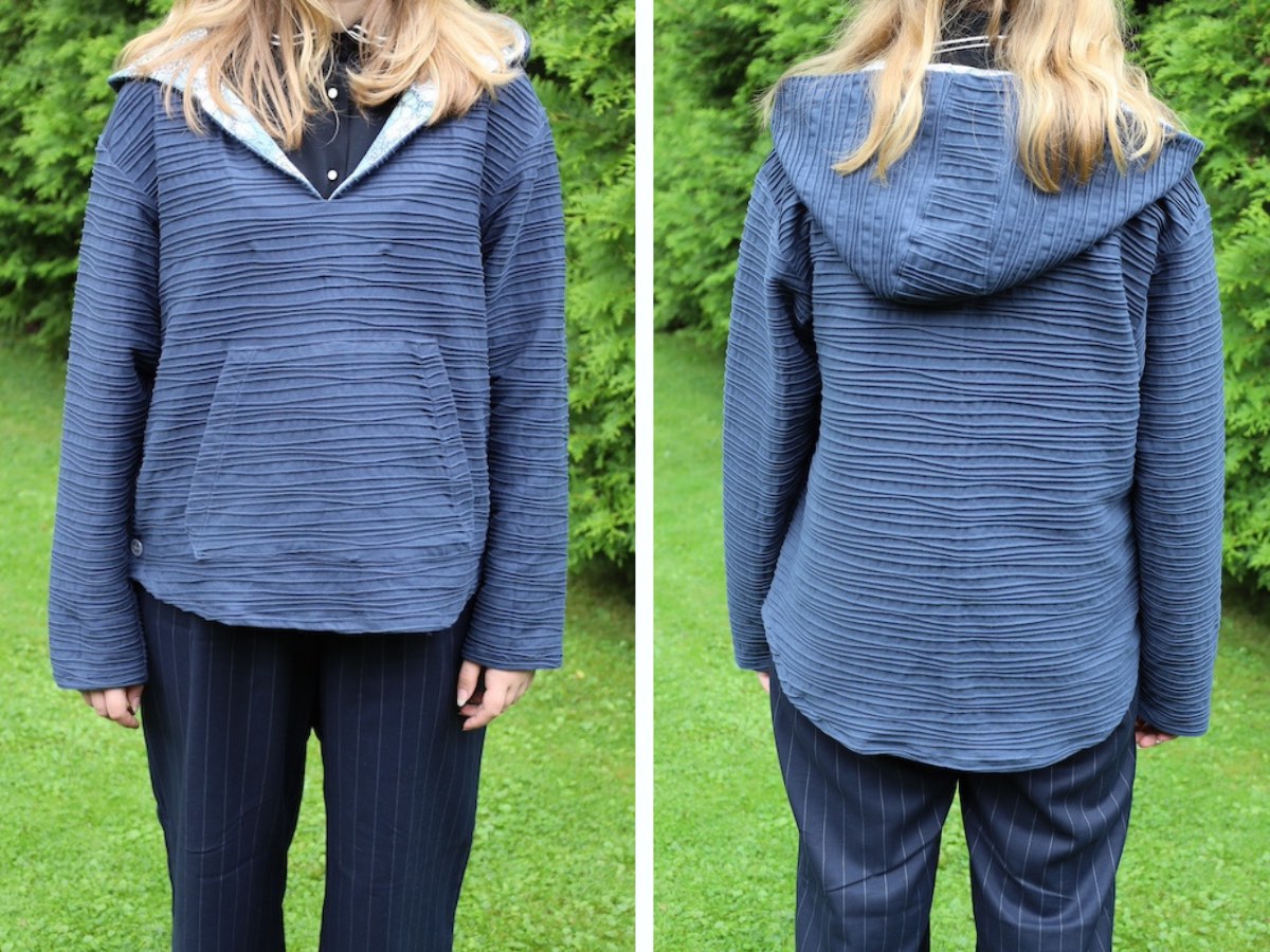 teenaged girl wears a hooded gray pullover with a v-neck collar and button sides. 