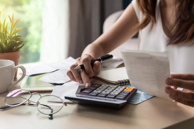 A woman is calculating her monthly energy bill.