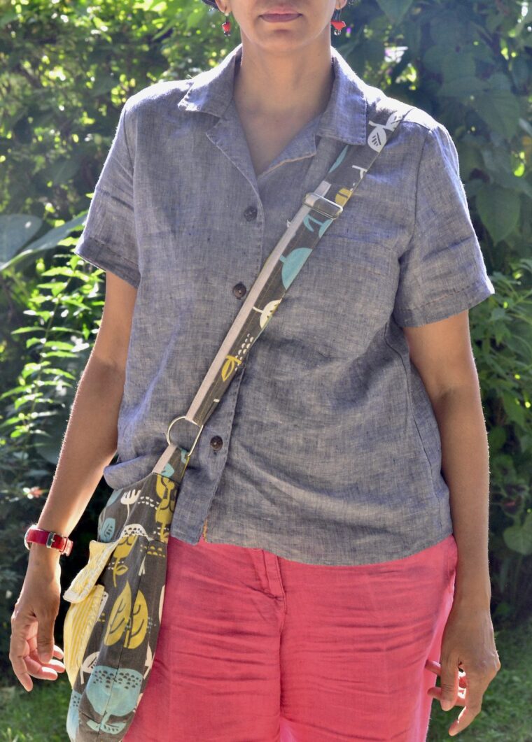 Woman standing outside wearing a button-up pajama shirt with day shorts