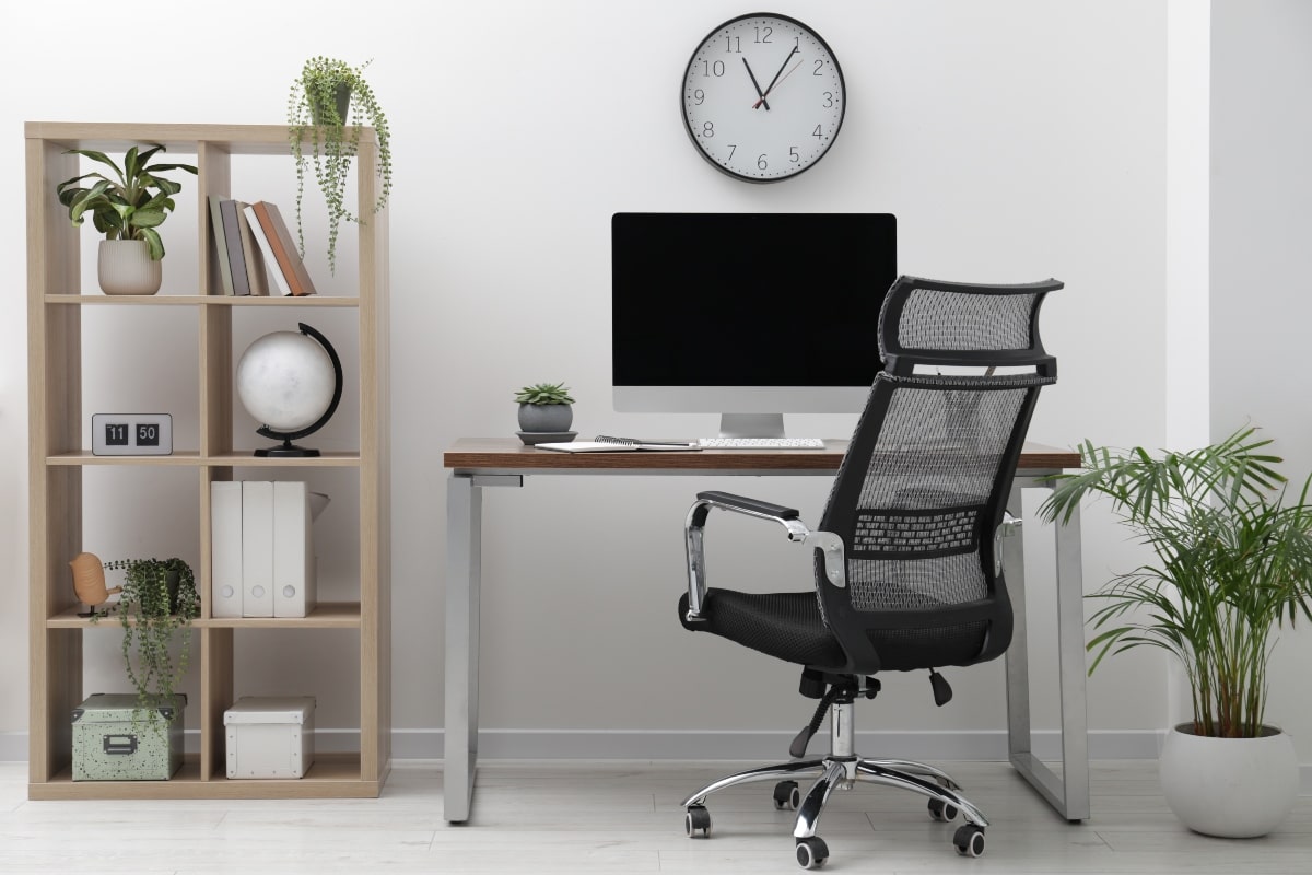 Office workspace featuring a drafting chair with mesh back support, illustrating the practical design of drafting chairs for professional environments.