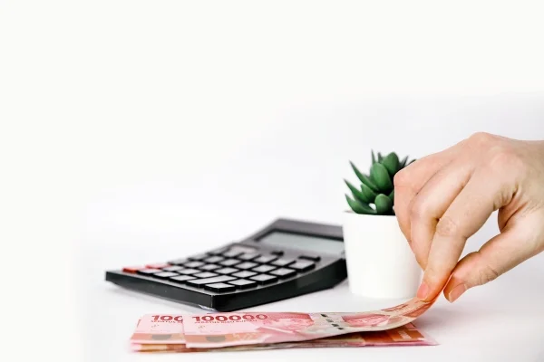 hand-taking-one-sheet-indonesian-rupiah-paper-currencies-beside-calculator
