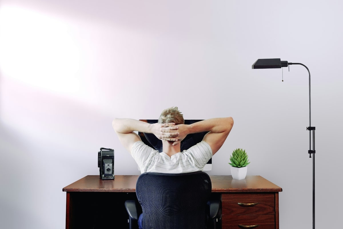 A man leaning back comfortably in an ergonomic office chair while working at a desk.