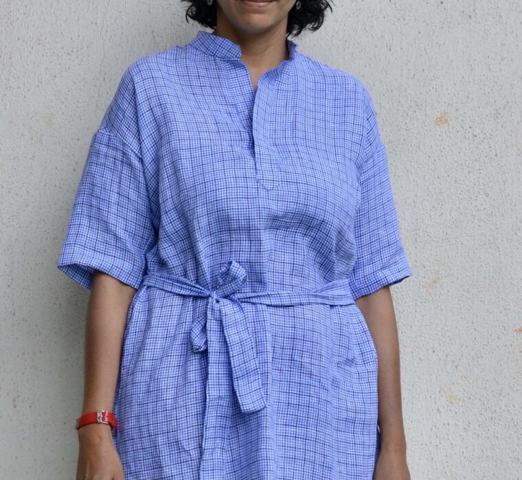 Close-up of a woman wearing the blue linen Santa Rosa Dress. The dress is cinched with a belt.