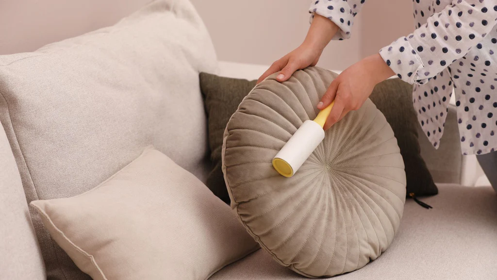 Woman Cleaning Pillow with Lint Roller