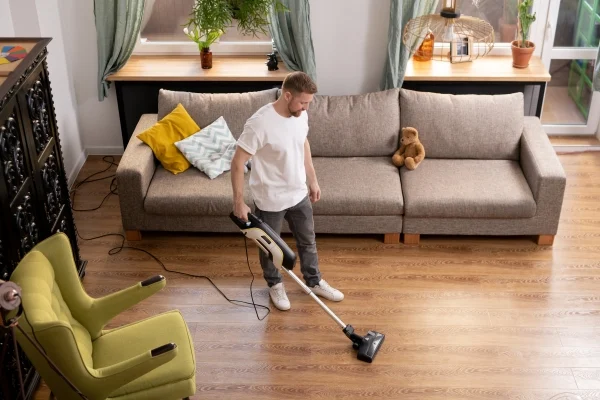Man Cleaning Floor with Vacuum Cleaner