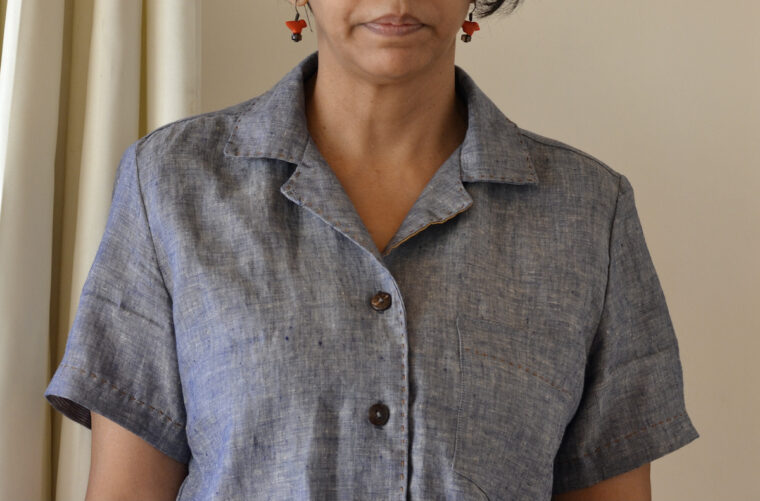 Close up of woman wearing a button-down shirt, detailing running stitch embroidery