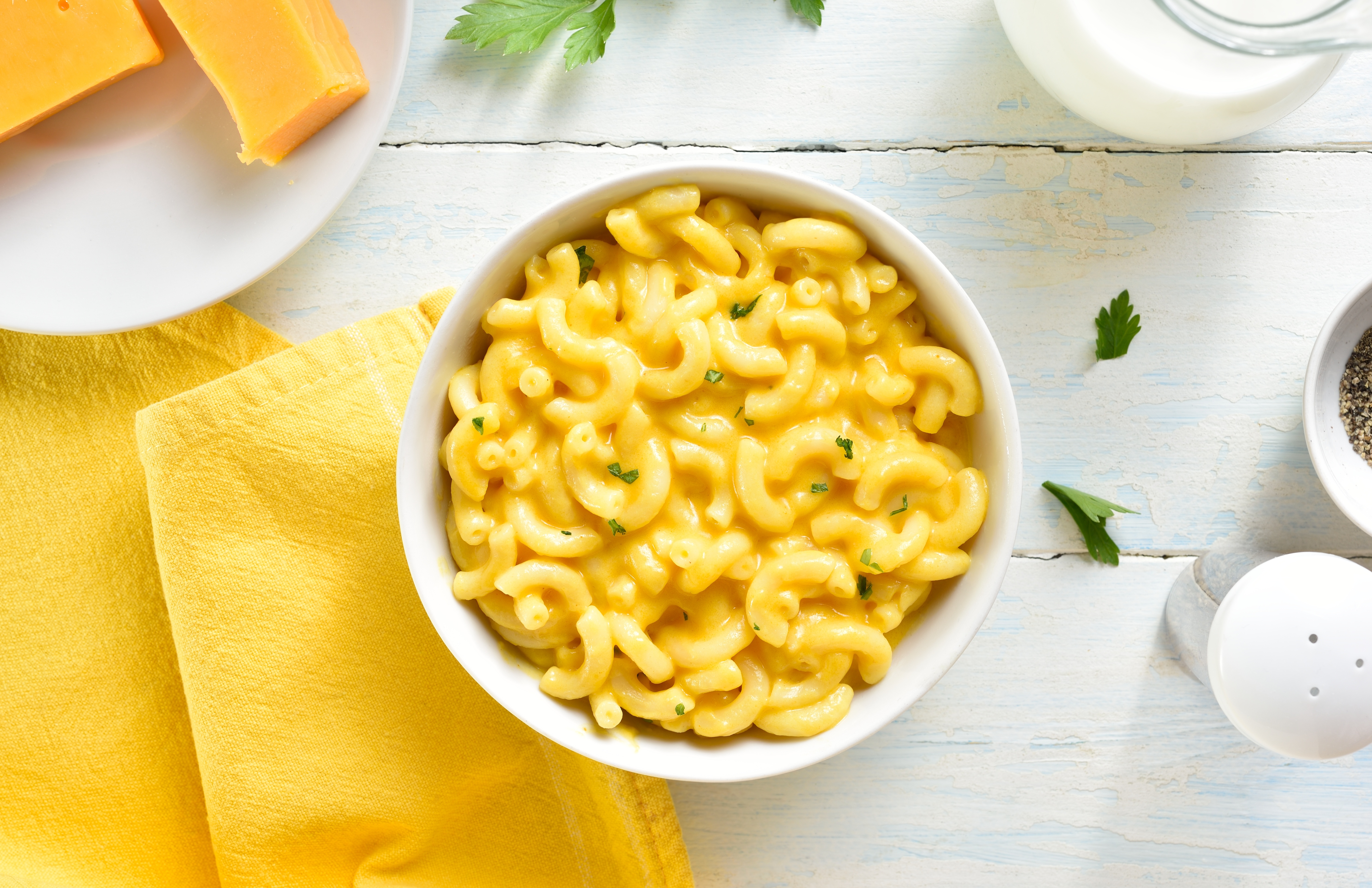 a bowl of mac n cheese next to a yellow napkin