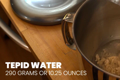 Mixing bowl with dough, nearby lid.