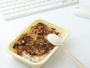 Unhealthy lunch box at office Plastic food container and plastic fork