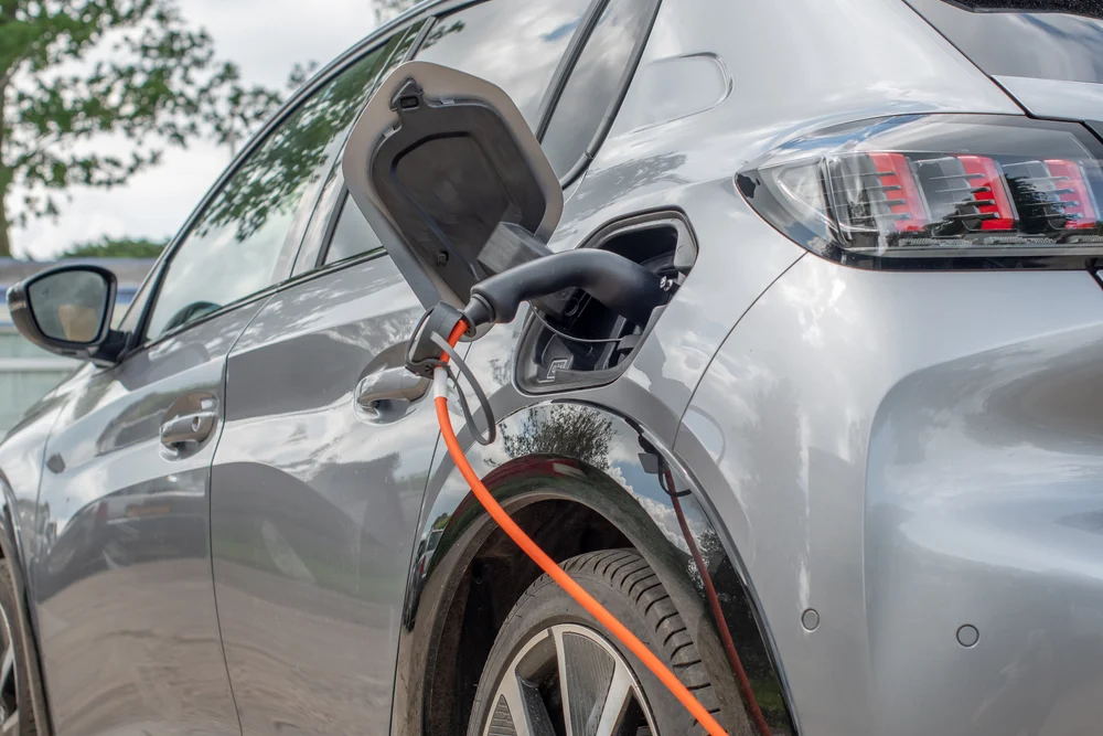 An electric car charging in a garage.