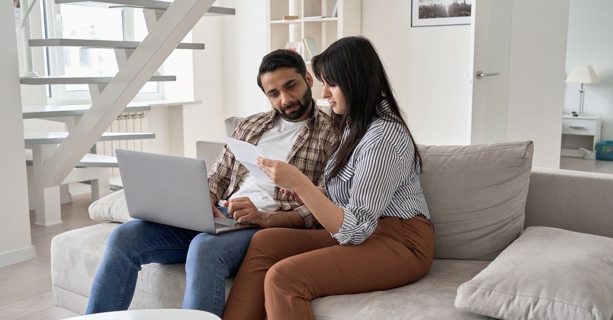 Young indian couple checking paper bills