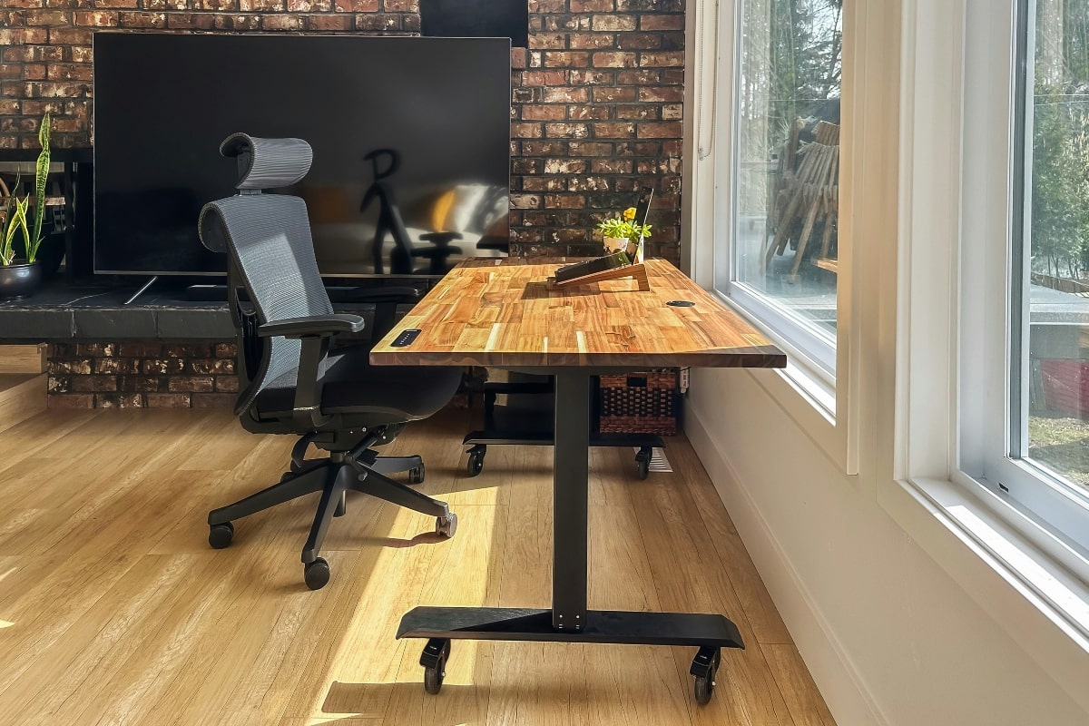 Ergonomic mesh office chair and adjustable desk setup in a bright, modern workspace.