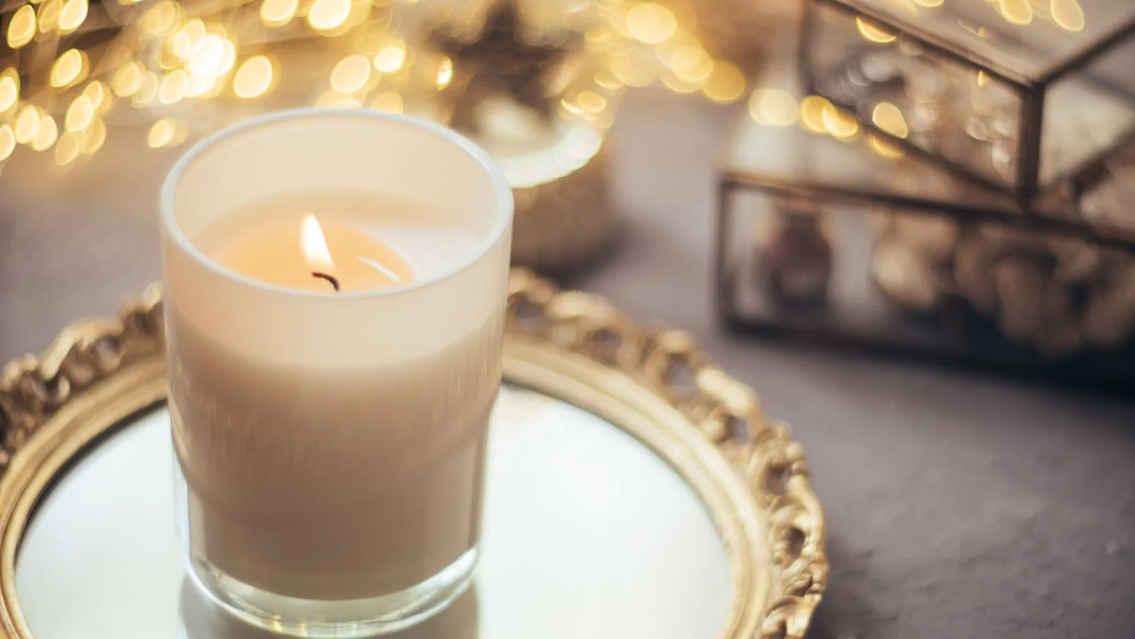 A candle on a mirrored tray