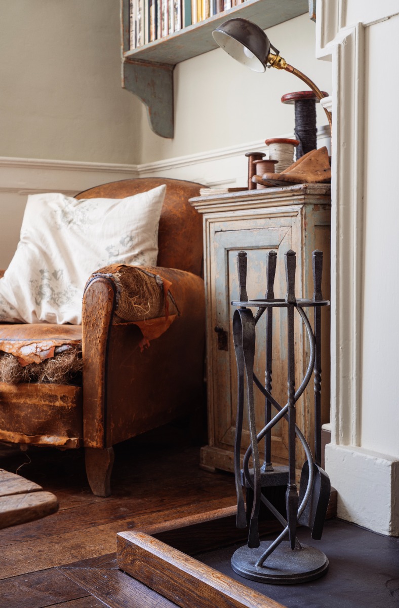 A decorative fireside companion set next to a fireplace.
