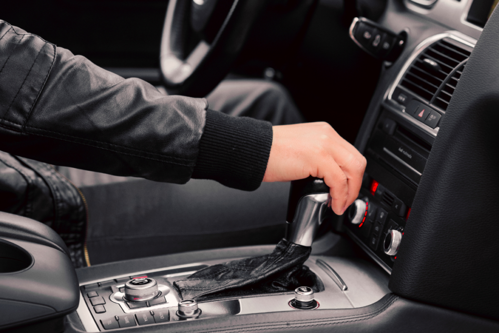 Person with their hand resting on the gearstick
