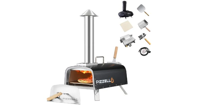 Portable outdoor pizza oven with chimney, pizza inside, and accessories: pizza peel, thermometer, gas attachment, and carry bag.