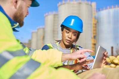 two construction workers looking at a screen on a construction site