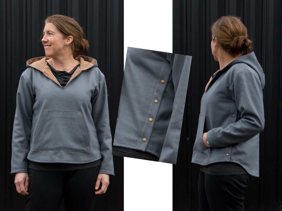 Woman wearing gray hooded pullover top with tan lining and copper colored side snaps