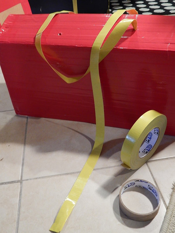 With the longer flaps of the top side of the box folded back down inside, I poked 4 small holes with a scissor and then pushed through my straps.