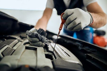 Austin auto mechanic checking a carâ€™s oil levels