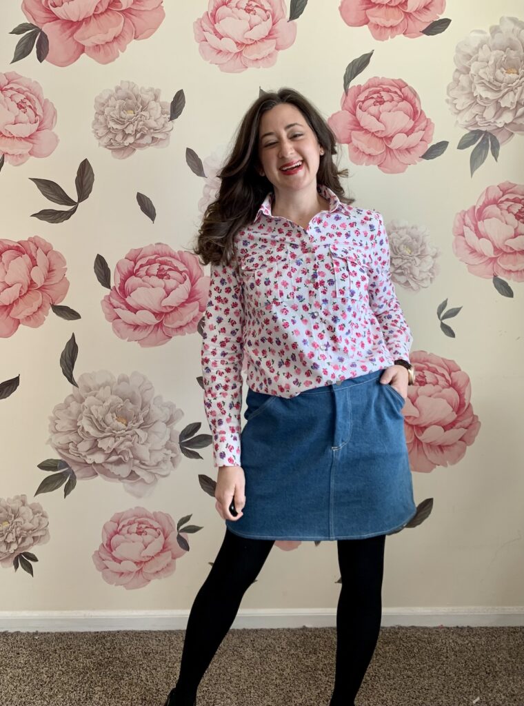 Front view of a woman wearing a button-down shirt and a denim skirt.