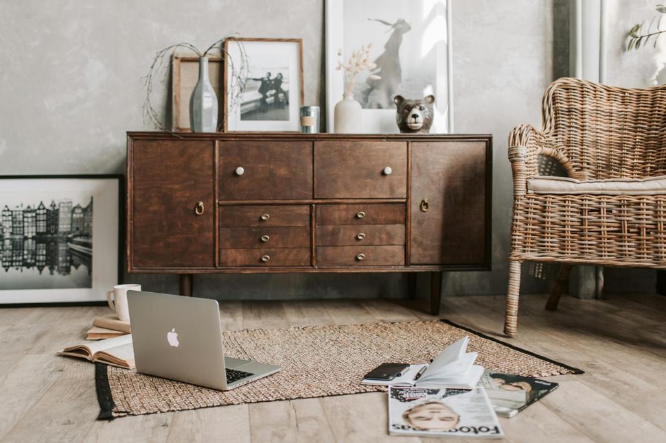 old dark wooden sidetable next to rattan chair