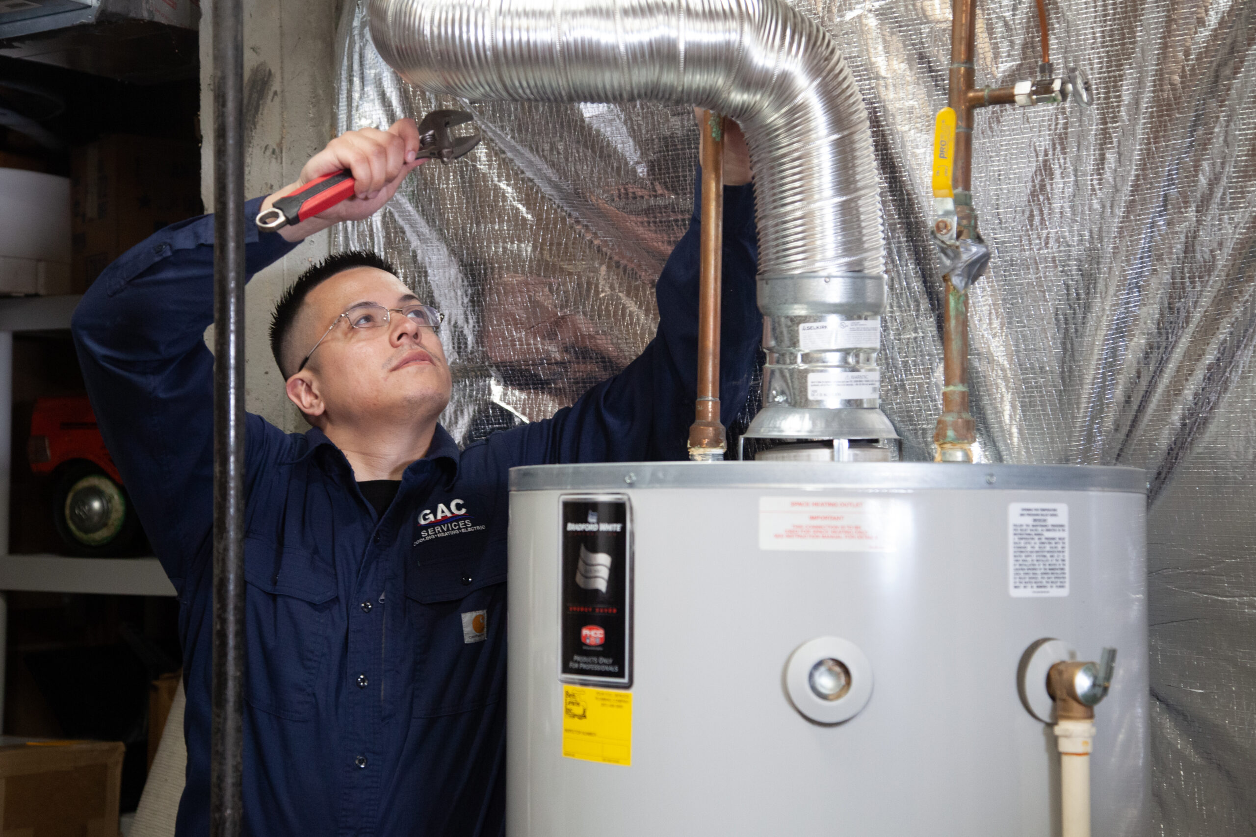 Technician working with HVAC during a maintenance plan home visit
