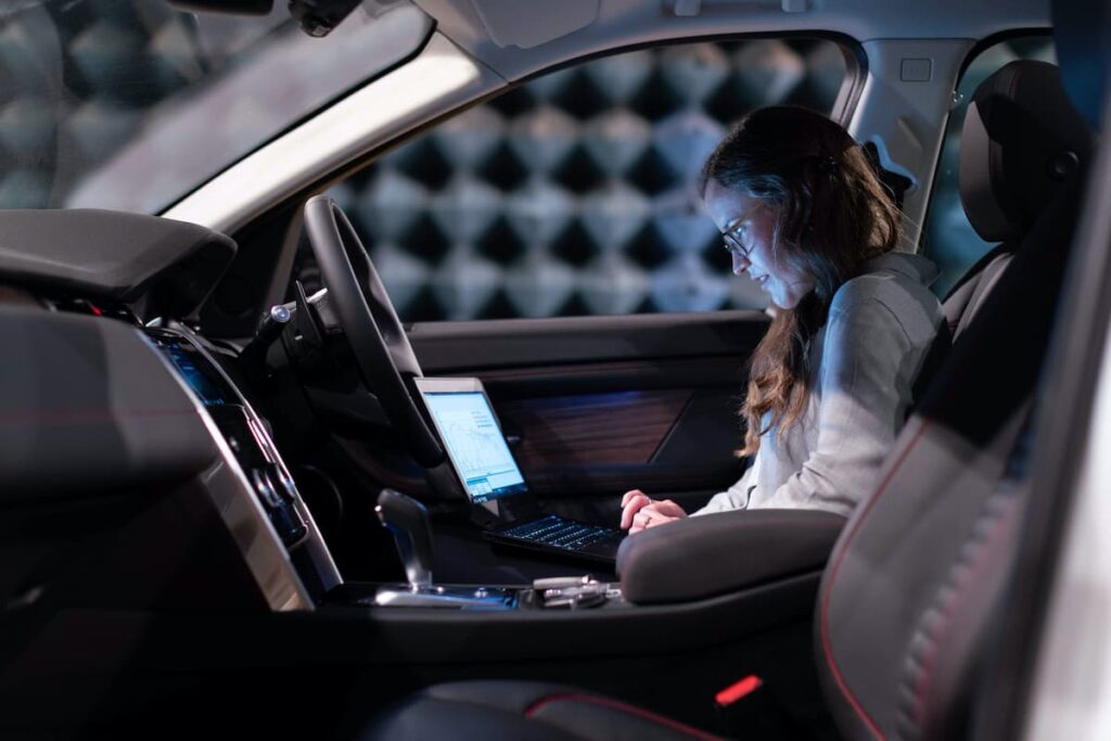 A woman seated comfortably inside an autonomous vehicle.