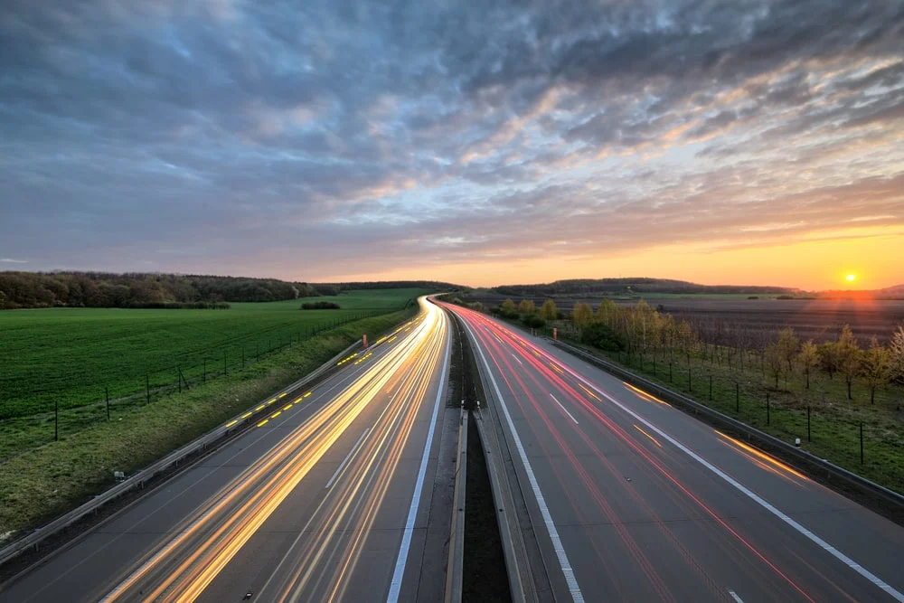A highway at sunset with fast motion lines.