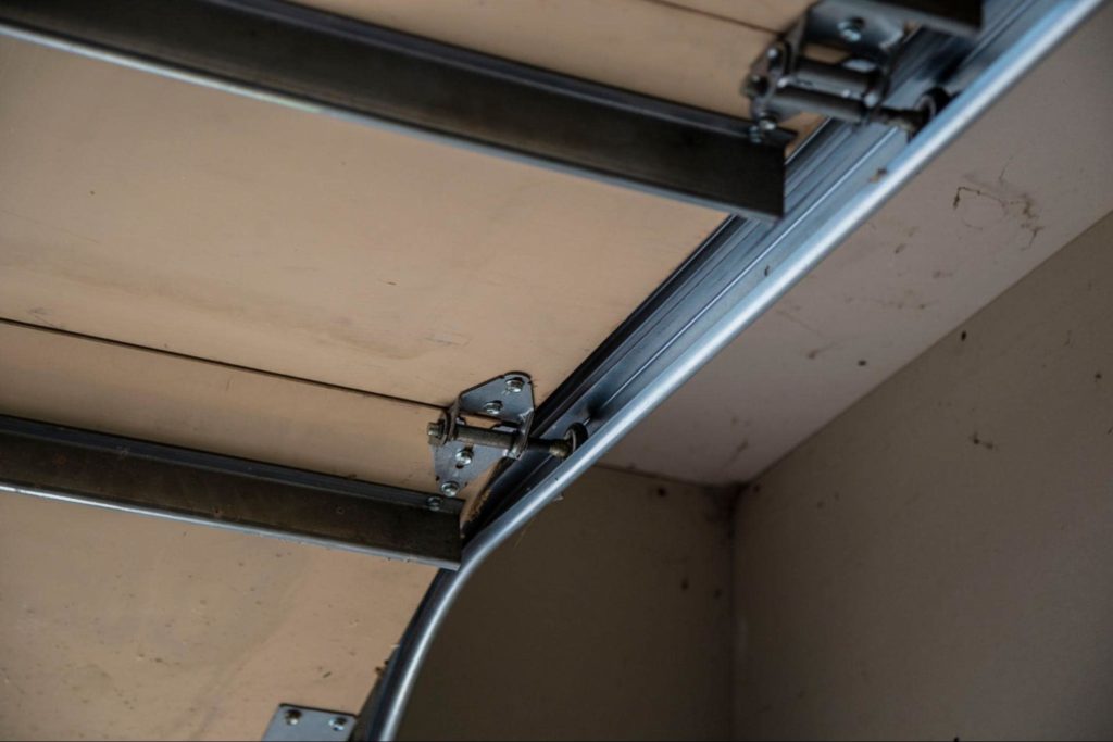 Up close view of a garage door track when the garage door is opening.