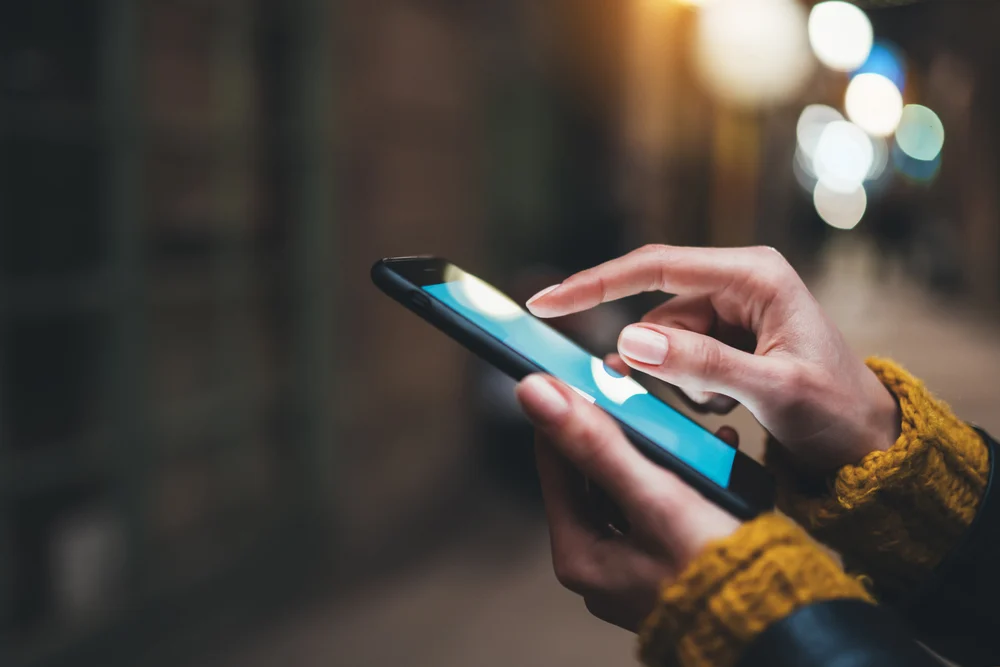 A closeup of a woman holding a smartphone.